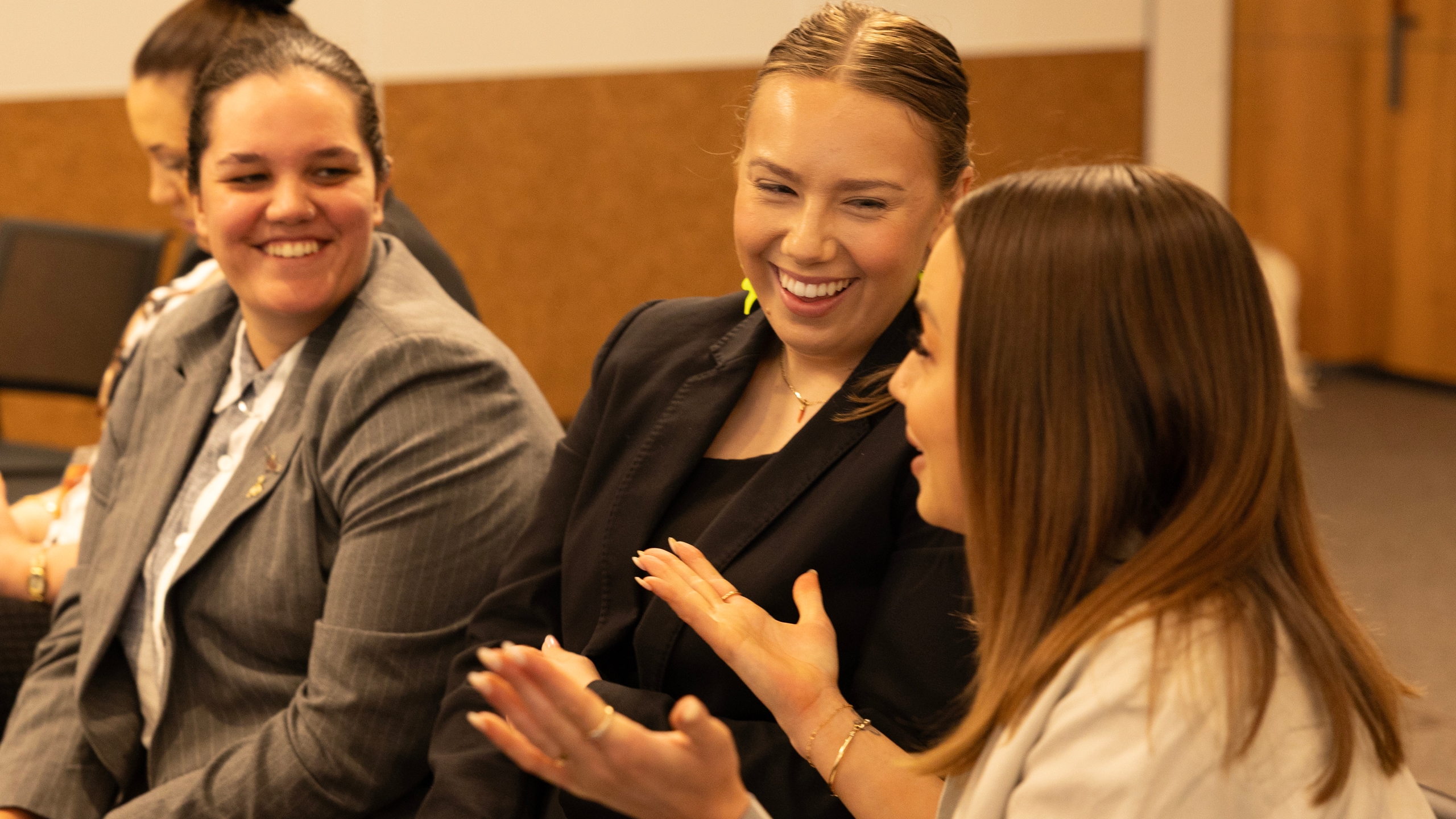 CareerTrackers staff and interns laughing together in conversation at a program event.